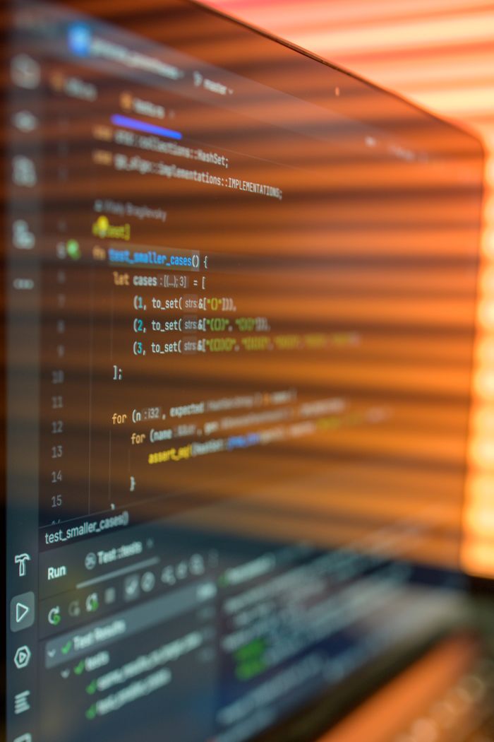 Home Close-up image of a computer screen displaying colorful programming code in a warm setting.